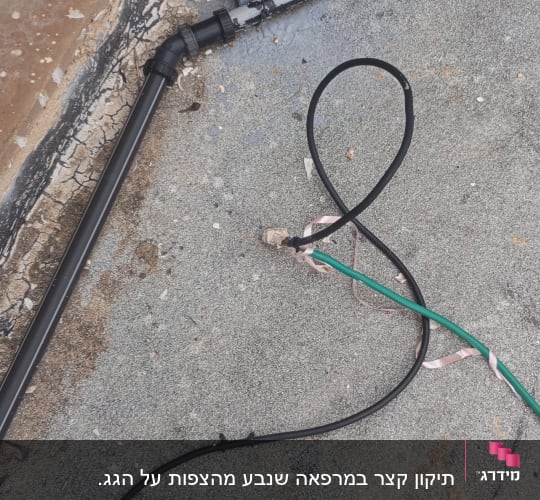 כבלים חשמליים שחורים וירוקים על רצפה אפורה